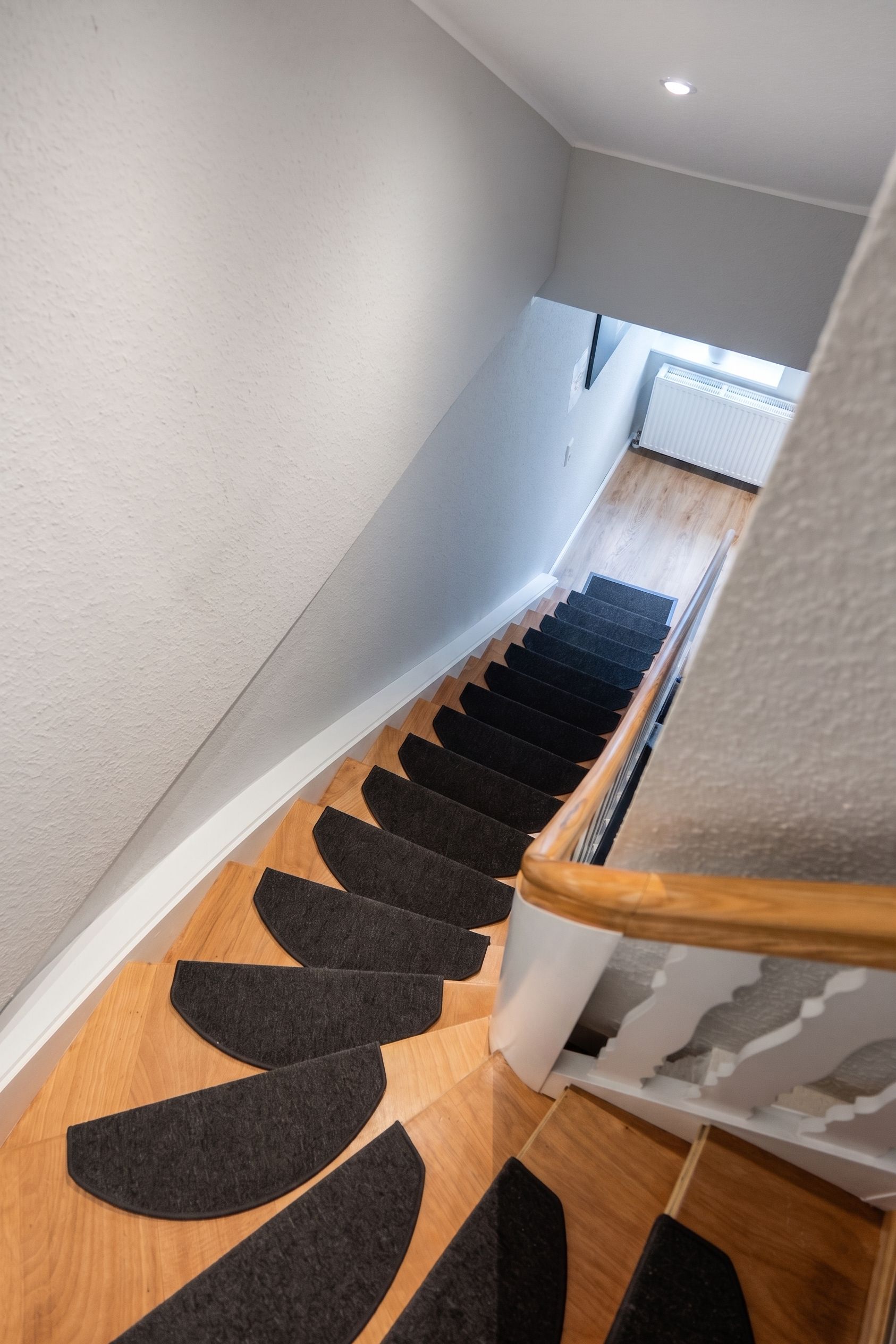 Eine Treppe mit Holzausstattung und schwarzen Teppichläufern.