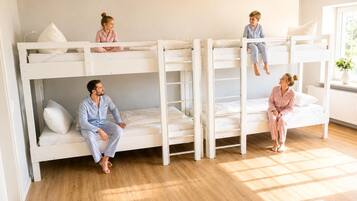 Une chambre avec un lit superposé où dorment quatre personnes, une sur chaque lit.
