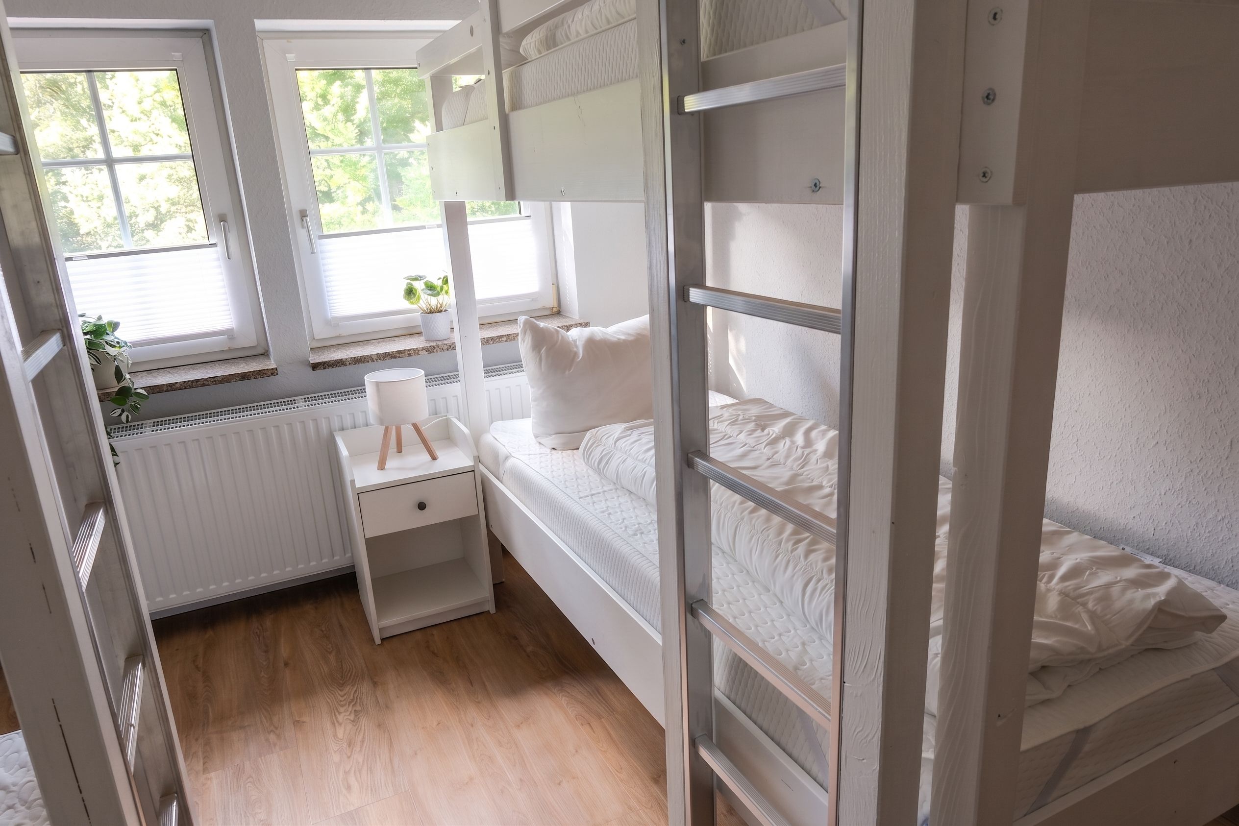 Habitación con literas, escritorio y radiador.