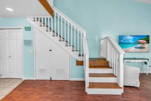 Eine Treppe mit weißen Geländern und Holzstufen, die zu einer Zwischenebene führt.