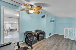 A room with a ceiling fan, a white railing, and a door leading to another room. - On the Intracoastal | Pool | Fishing Pier | Walk to Beach | Indian Sands B3 (Indian Shores)