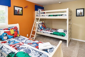 Quarto com beliche decorado com tema de super-heróis, escada e duas molduras nas paredes.