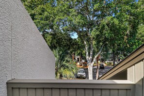A residential area with a view of a street, parked cars, and trees. - Sunset Rentals | Tennismaster 703 | Dog Friendly (Hilton Head Island)