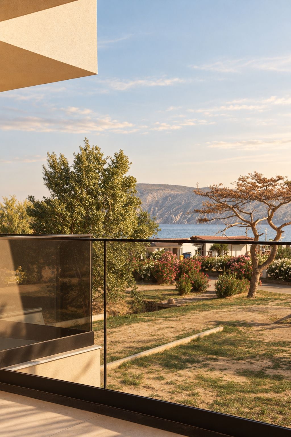 A balcony with a view of a landscaped garden and a body of water.