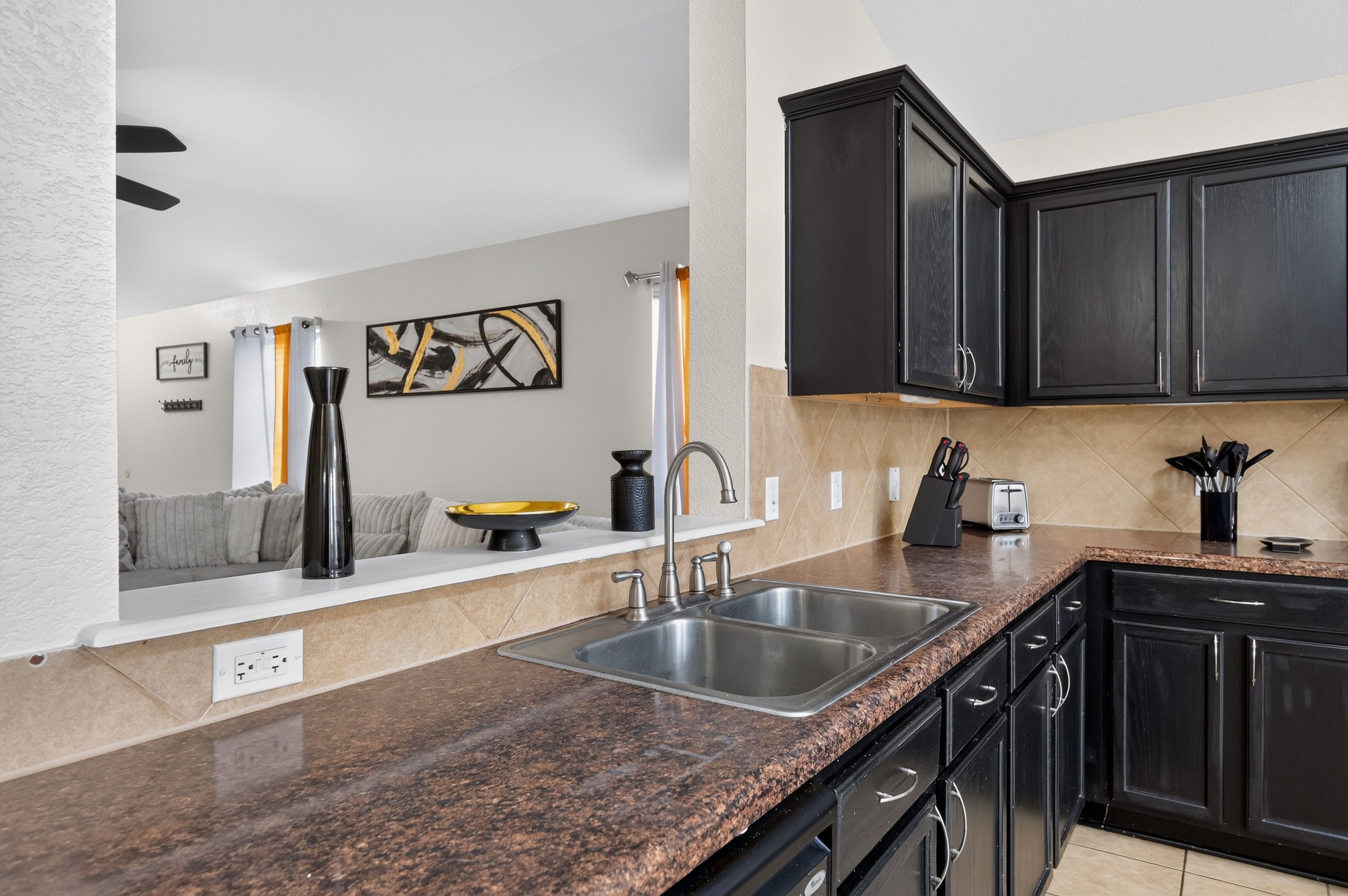 A kitchen with granite countertops, stainless steel appliances, and dark cabinetry.