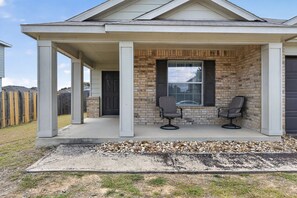 A residential building with a covered porch, two chairs, and a door. - New! Spacious 3BR Retreat Near Fort Hood Killeen (Killeen)
