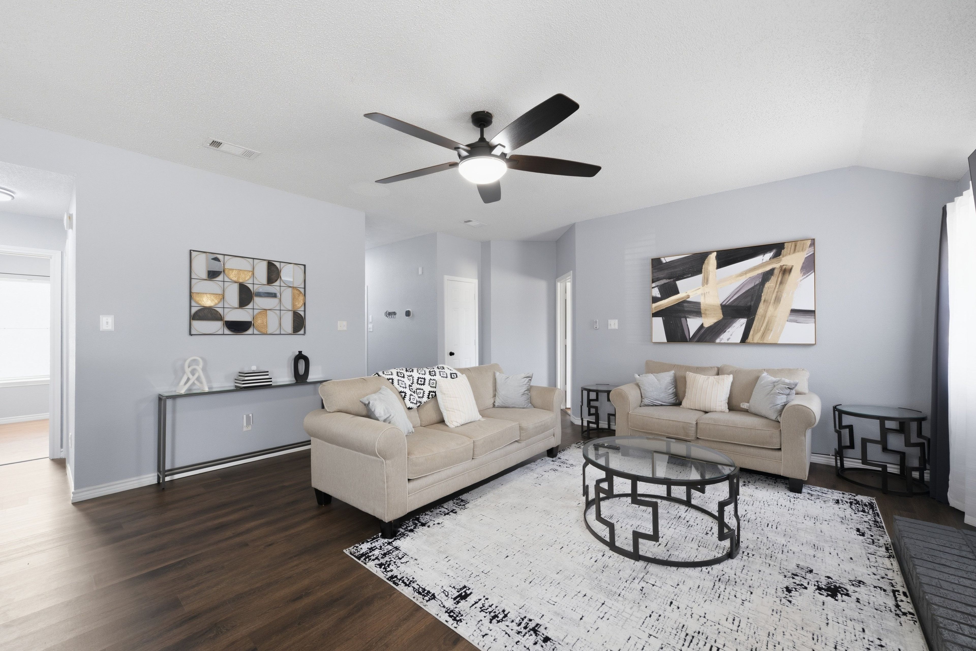 A modern living room with two sofas, a coffee table, and artwork on the walls.