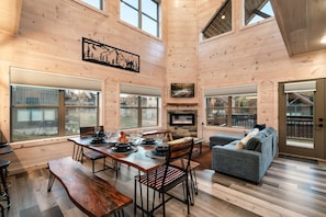 A spacious interior with a dining area, a fireplace, and a cozy seating area. - Smokiedoki Lodge 3 Bedroom Cabin (Pigeon Forge)