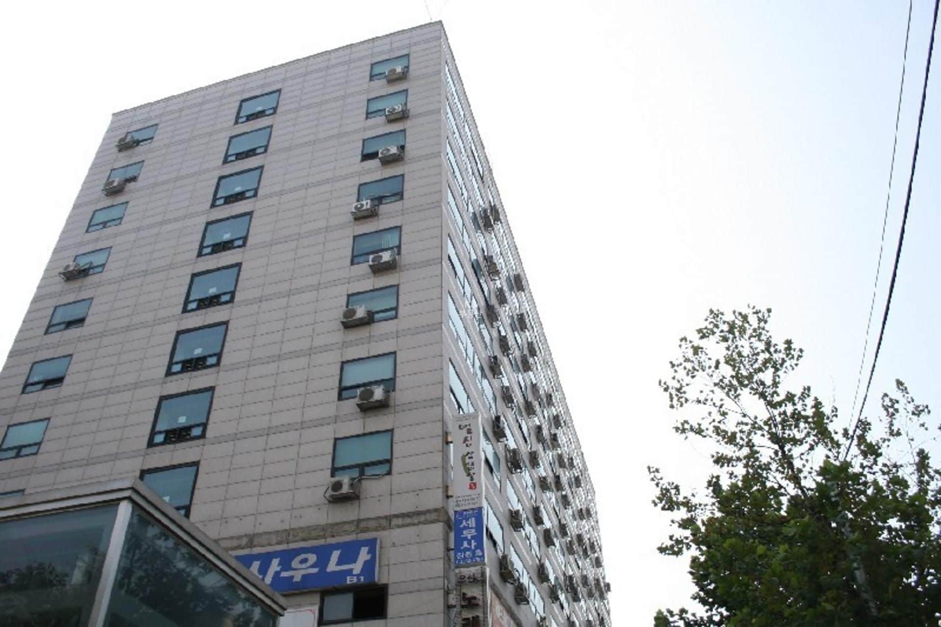 A multi-story building with numerous windows and air conditioning units.