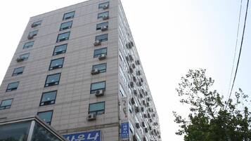 A multi-story building with numerous windows and air conditioning units.