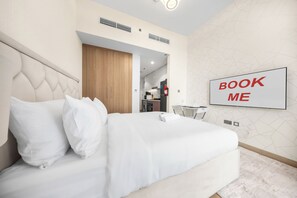 Ein modernes Hotelzimmer mit einem großen Bett, einem Wand-Fernseher und einem Schild mit der Aufschrift 'BOOK ME'.