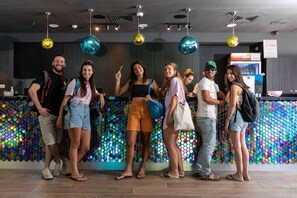 A group of people standing in a modern interior with a colorful, patterned wall and pendant lighting. - Be-city Hotel Eilat (Eilat)