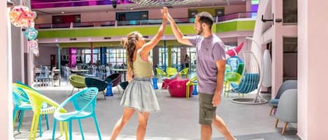 A spacious indoor area with multiple levels, colorful seating, and a central decorative structure.