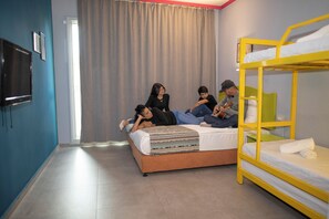 A room with a bed, a bunk bed, a TV, and a curtain. - Be-city Hotel Eilat (Eilat)