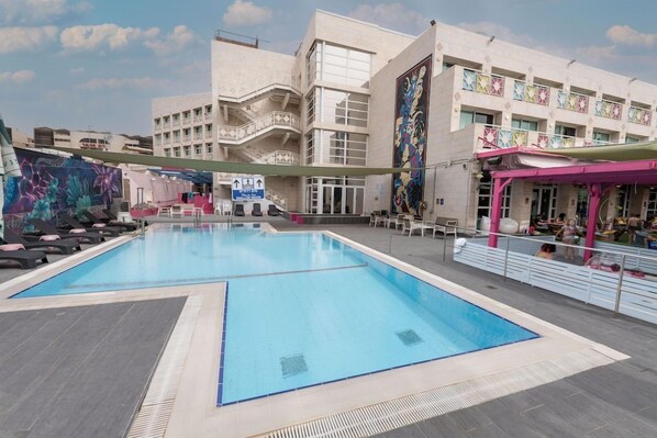 Zona de piscina con un edificio al fondo.