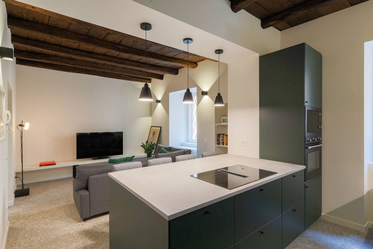 A modern kitchen with a central island, built-in appliances, and pendant lighting.