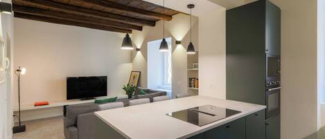 A modern kitchen with a central island, built-in appliances, and pendant lighting.