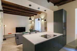 A modern kitchen with a central island, built-in appliances, and pendant lighting. - Casa Noce by J&CO Homes (CERNOBBIO)