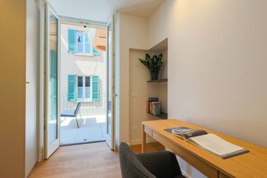 A narrow hallway with a wooden table and a chair, a potted plant, and a bookshelf. - Casa Noce by J&CO Homes (CERNOBBIO)