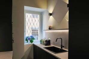 Eine moderne Küche mit integriertem Spülbecken, einem Fenster mit Blick und einer kleinen Ablagefläche mit einem dekorativen Gegenstand.