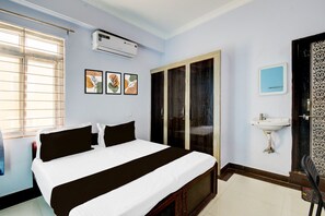 Un dormitorio con cama, aire acondicionado, ventana y puerta.