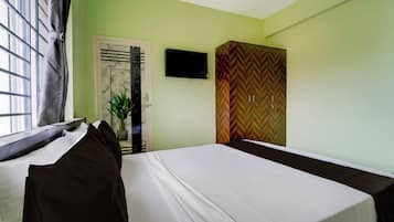 Een kamer met twee bedden, een televisie aan de muur en een inloopkast met een herringbone-motief.
