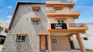 Un immeuble à plusieurs étages, doté d’une façade en pierre et d’un toit plat.