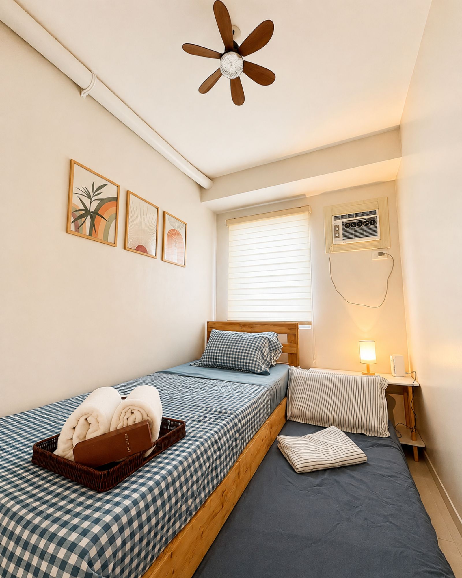 A bedroom with a single bed, a ceiling fan, a window with blinds, and a wall-mounted air conditioning unit.