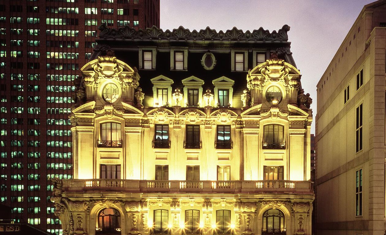 A historic building with ornate architectural details, large windows, and a balcony.