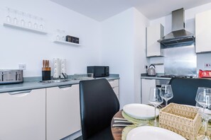Eine moderne Küche mit Essbereich, ausgestattet mit Toaster, Wasserkocher und Kaffeemaschine.
