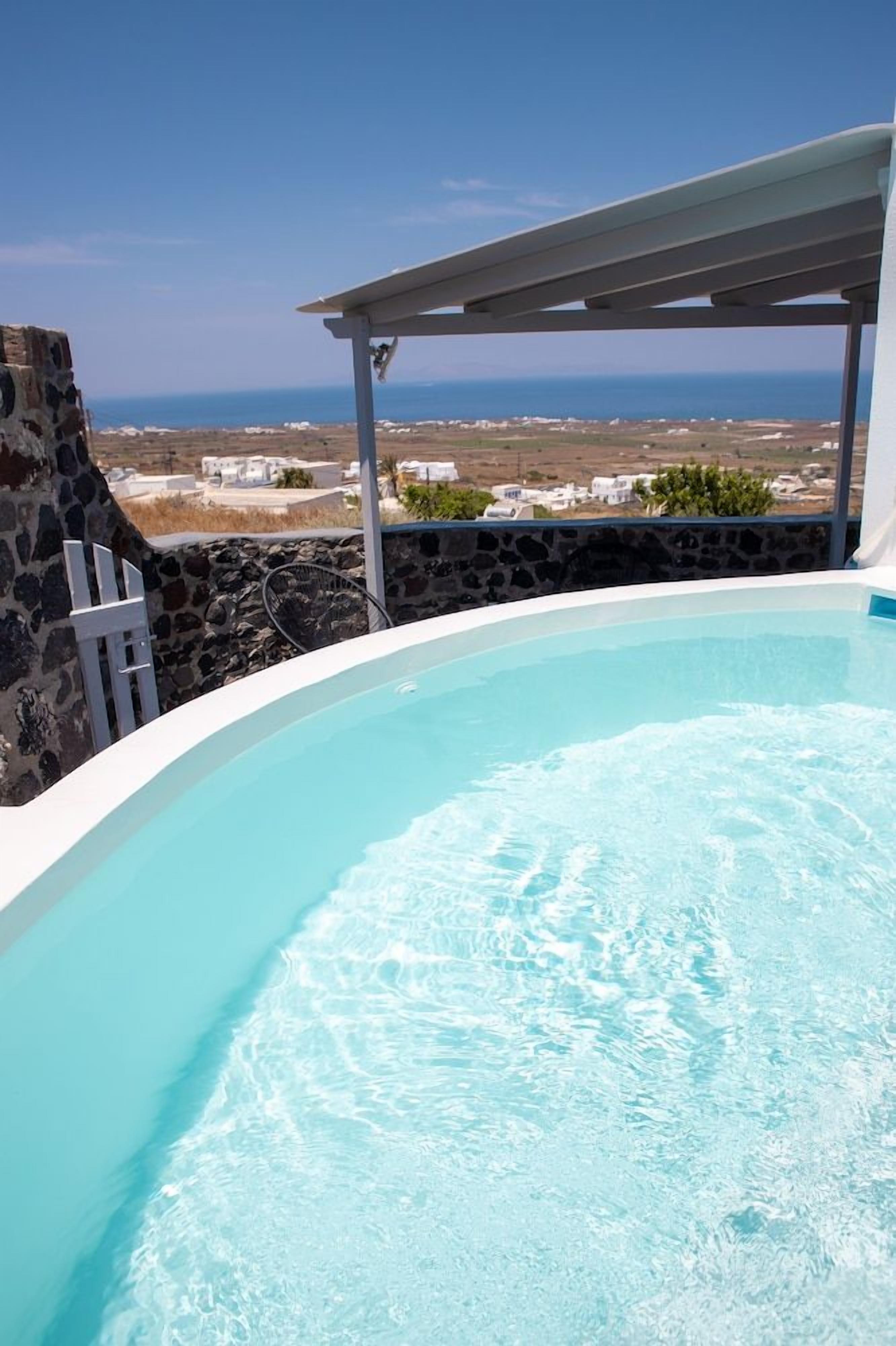 Una piscina con vistas al mar y edificios al fondo.