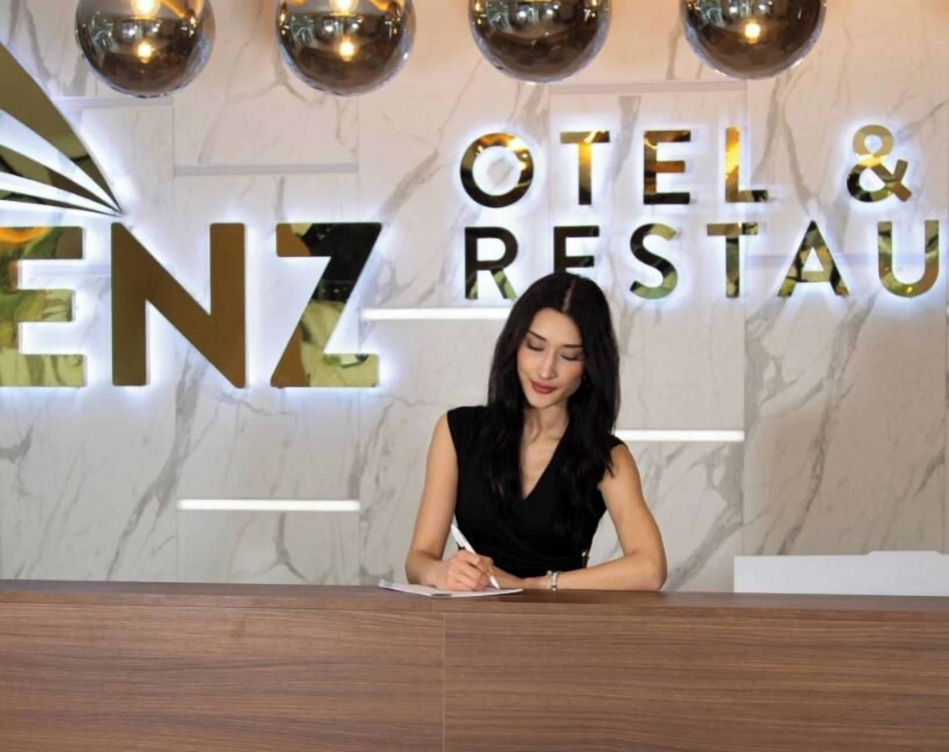 Een receptiebalie met een bord waarop 'HOTEL & RESTAURANT' staat, en de naam 'ENZ' in grote letters.