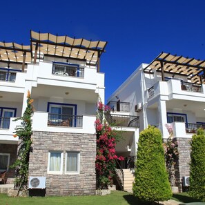 A two-story residential building with balconies, stone facade, and a clear blue sky. - Aktur Residence (Bodrum)