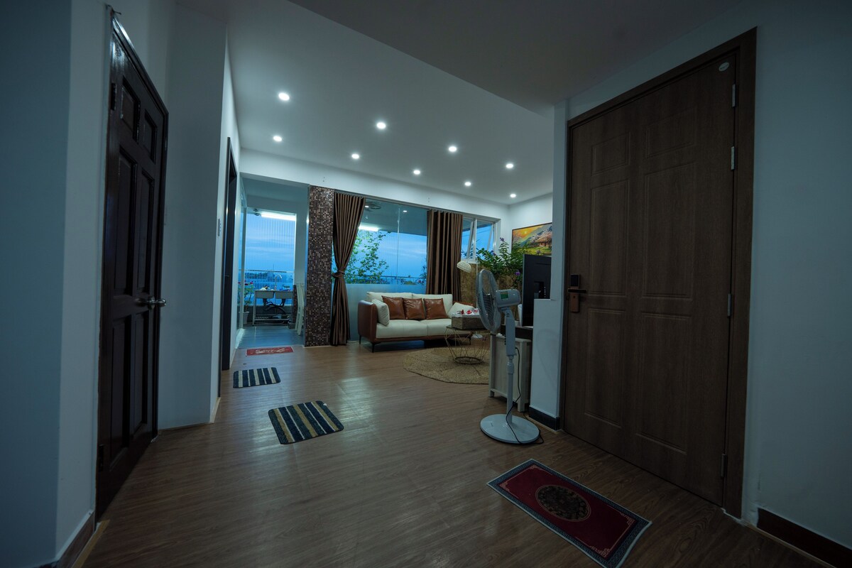 Uma sala de estar moderna com um sofá, uma mesa de centro e uma janela grande.