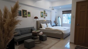 Un dormitorio moderno con cama, sofá, mesa de centro y un ventanal grande.