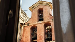 A bell tower with a cross on top, visible through an open doorway.