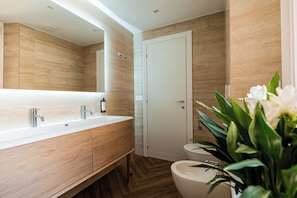 Une salle de bain moderne avec un meuble-lavabo en bois, un grand miroir et des toilettes.