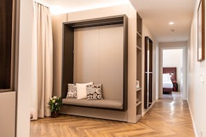 A modern hotel room with a built-in seating area, a potted plant, and a wooden floor. - The Monkey Hotel  (Roma)