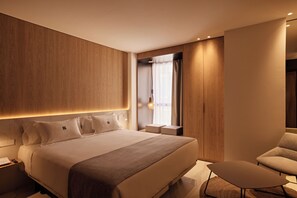Une chambre d’hôtel moderne avec un grand lit, une petite table et une chaise.