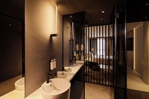 Une salle de bain moderne avec deux lavabos, une douche et une paroi en verre.