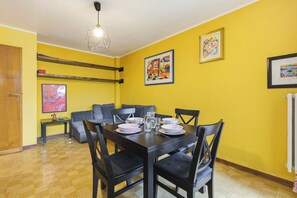 A dining area with a table set for four, a sofa, and a coffee table. - Two-room apartment in the heart of Sauze D'Oulx (Sauze d'Oulx)