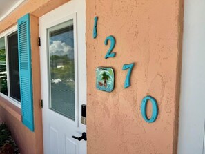 Una casa con una placa de número y una puerta con un ventanal.