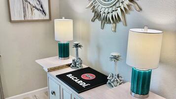 A bathroom with a vanity, two wall-mounted lamps, a decorative mirror, and a framed artwork.