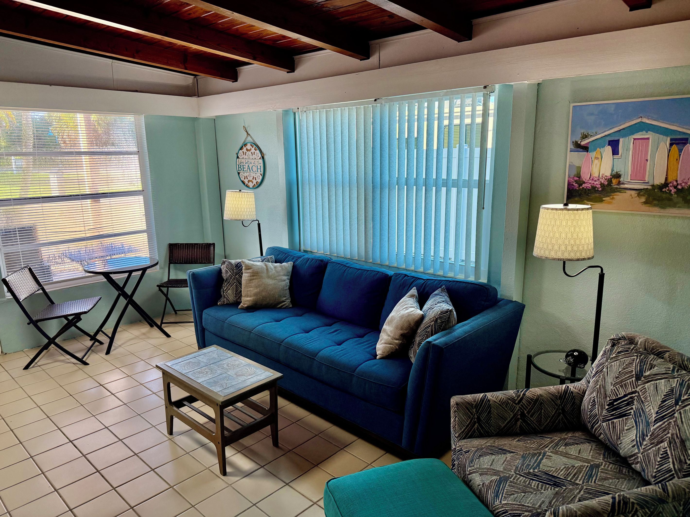 A living room with a blue sofa, a small table, and two chairs.