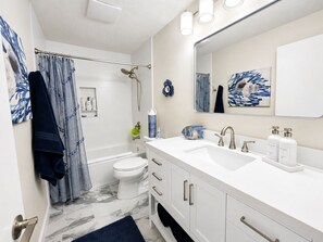Ein modernes Badezimmer mit Waschbecken, Spiegel und Dusche.