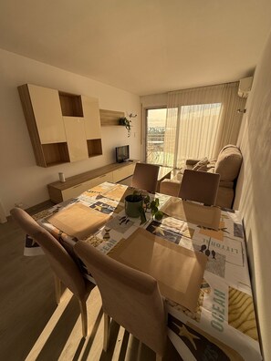 A modern dining area with a table set for four, surrounded by chairs. - Salou at Your Feet | Beach, Views, and Relaxation (Salou)