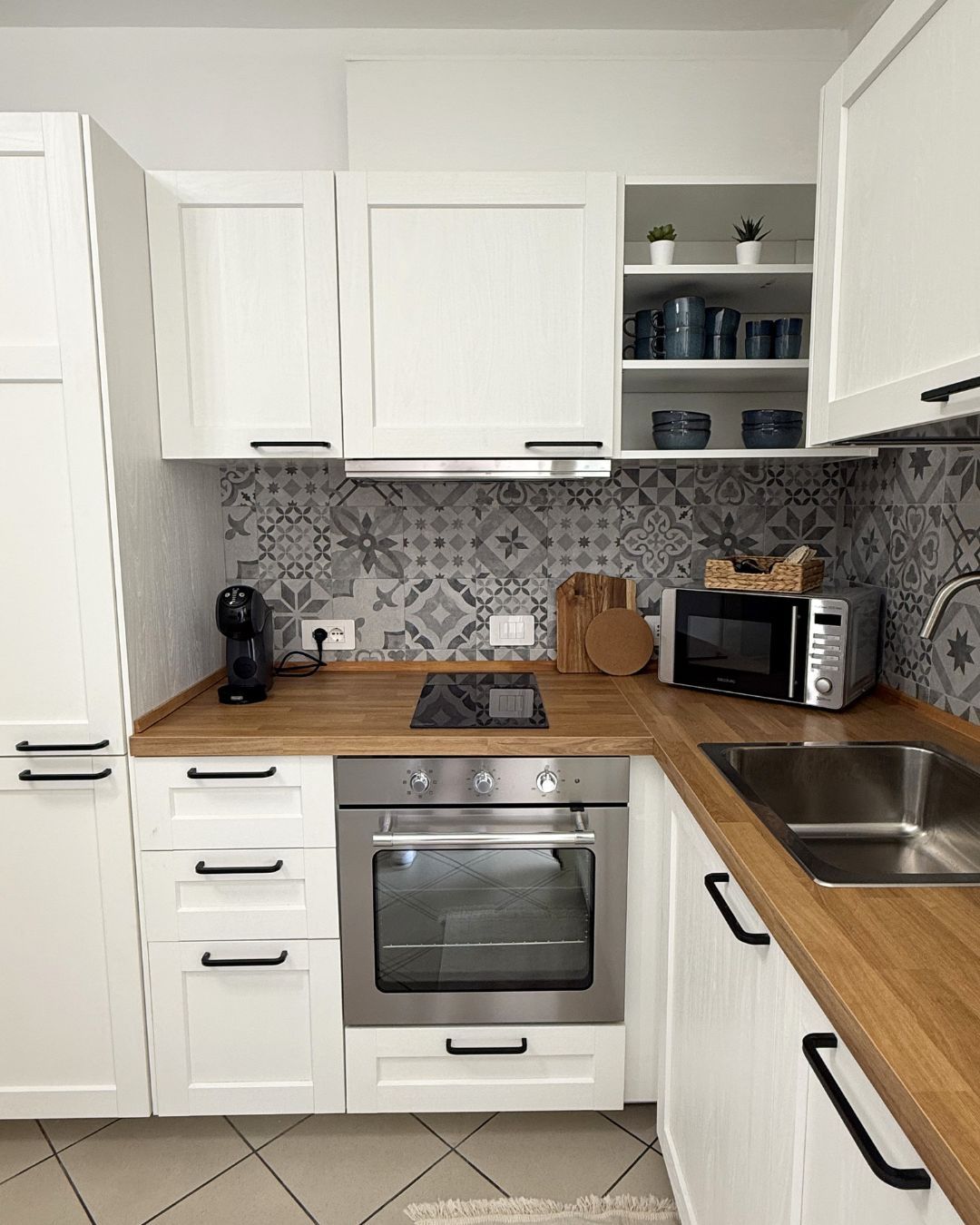A kitchen with white cabinets, a microwave, a toaster, and a coffee maker.