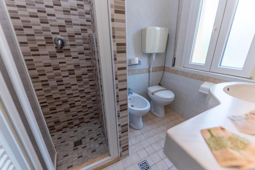 Un baño con ducha, inodoro, bidé y lavabo.
