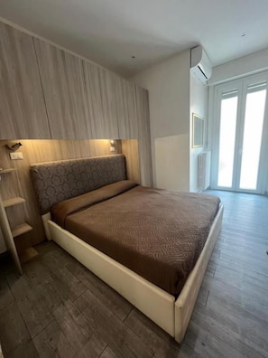 A bedroom with a bed, built-in wardrobe, and a window. - Hotel Villa Itala (Rimini)