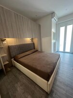 Un dormitorio con cama, armario empotrado y ventana.